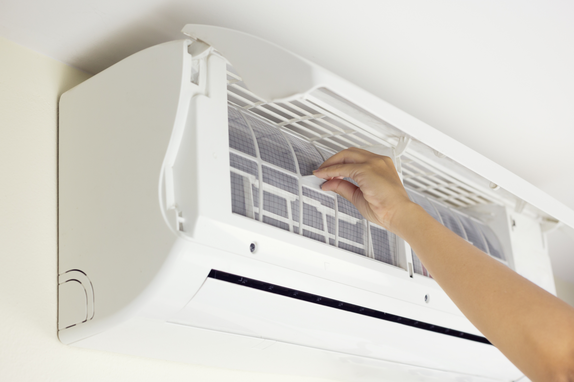 A Person Wiping Down an Air Conditioner With a Cloth.